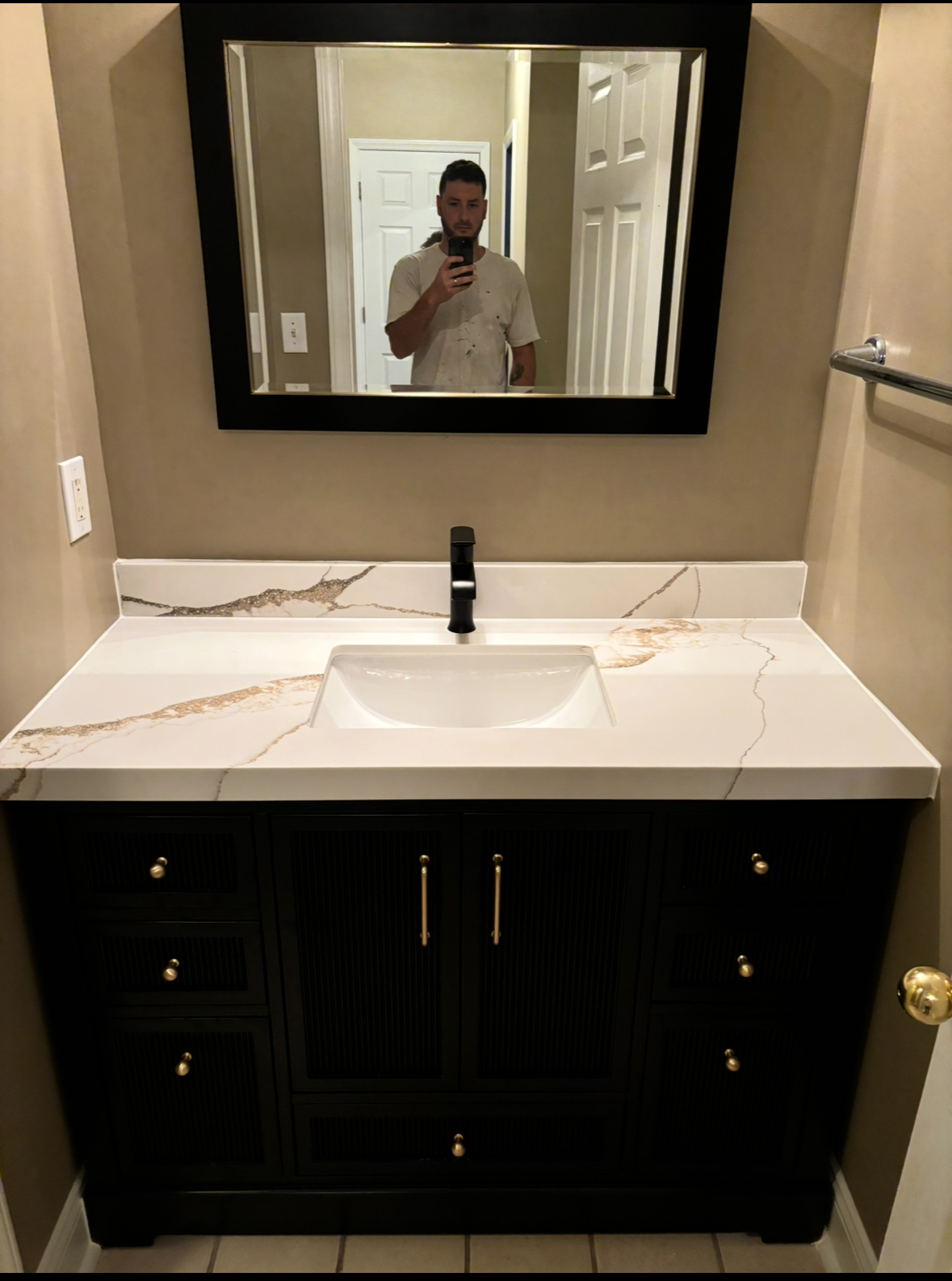 Bathroom vanity with black cabinet and white countertop