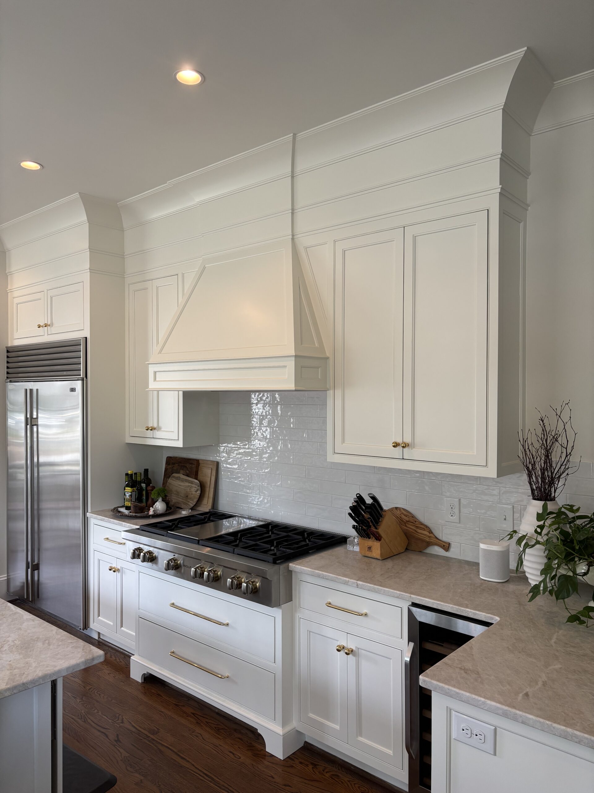 White kitchen with range hood and gas range