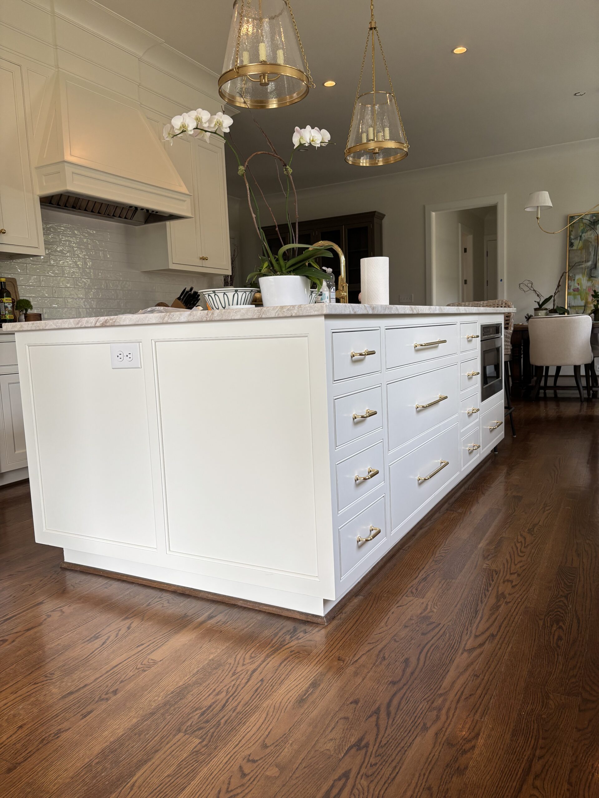 Remodeled kitchen with white island, pendant lights and hardwood floors