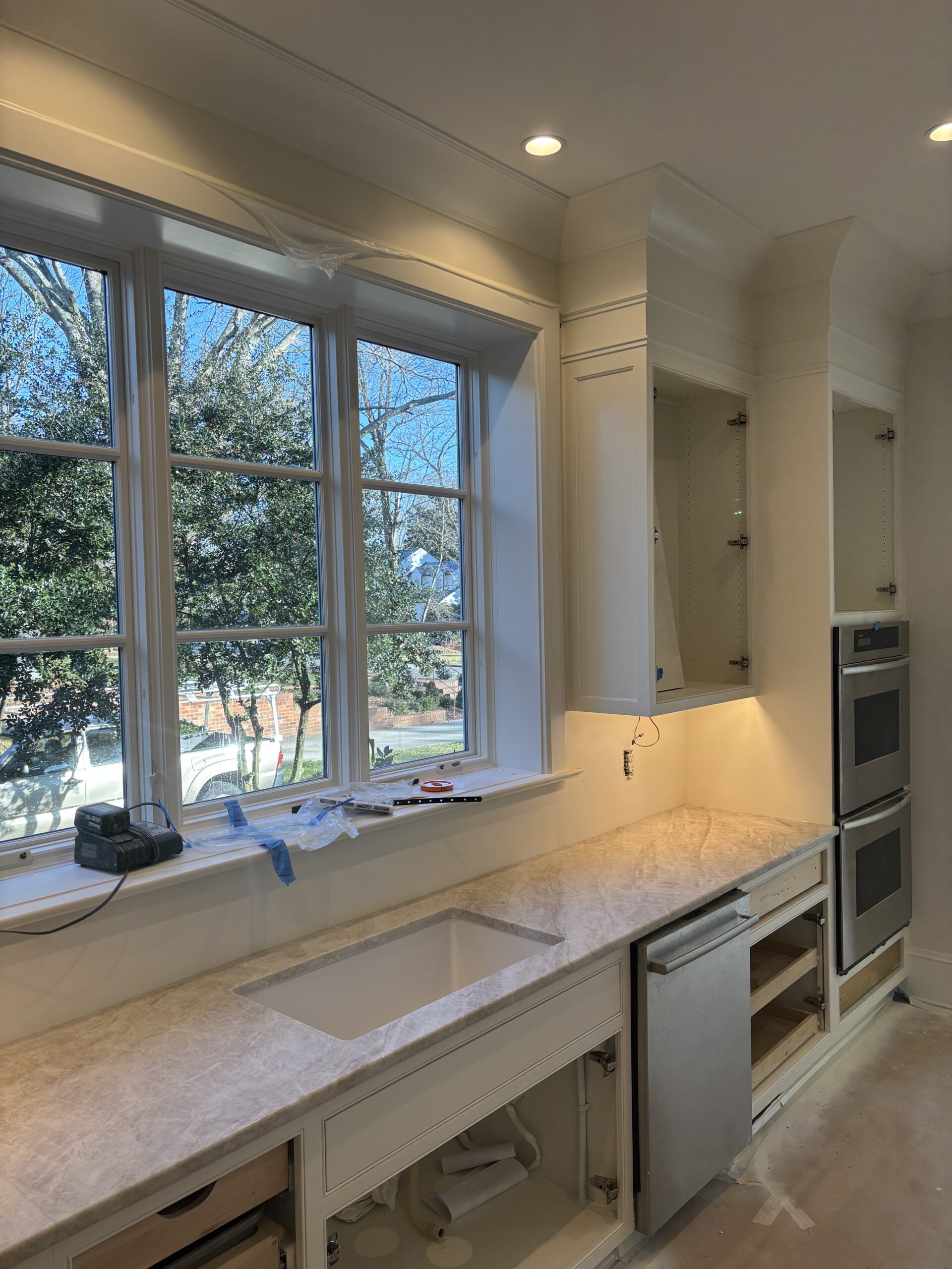 White kitchen with window sink area and light countertops