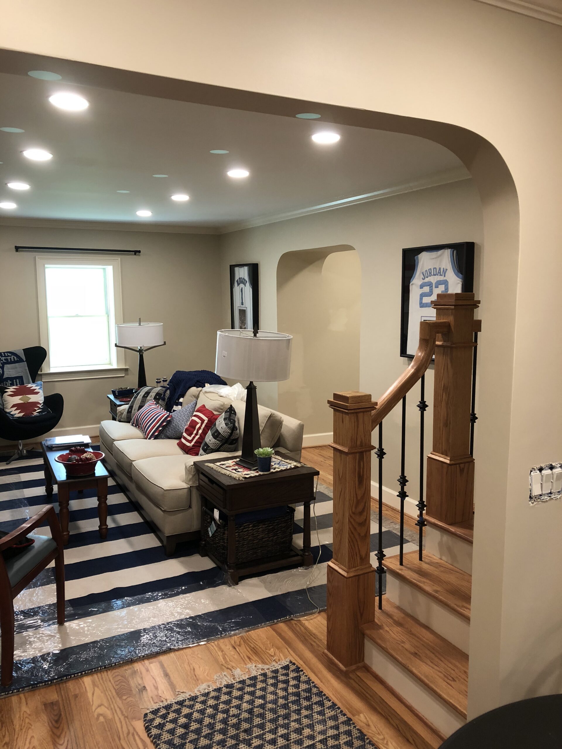 Living room with arched opening and wooden staircase