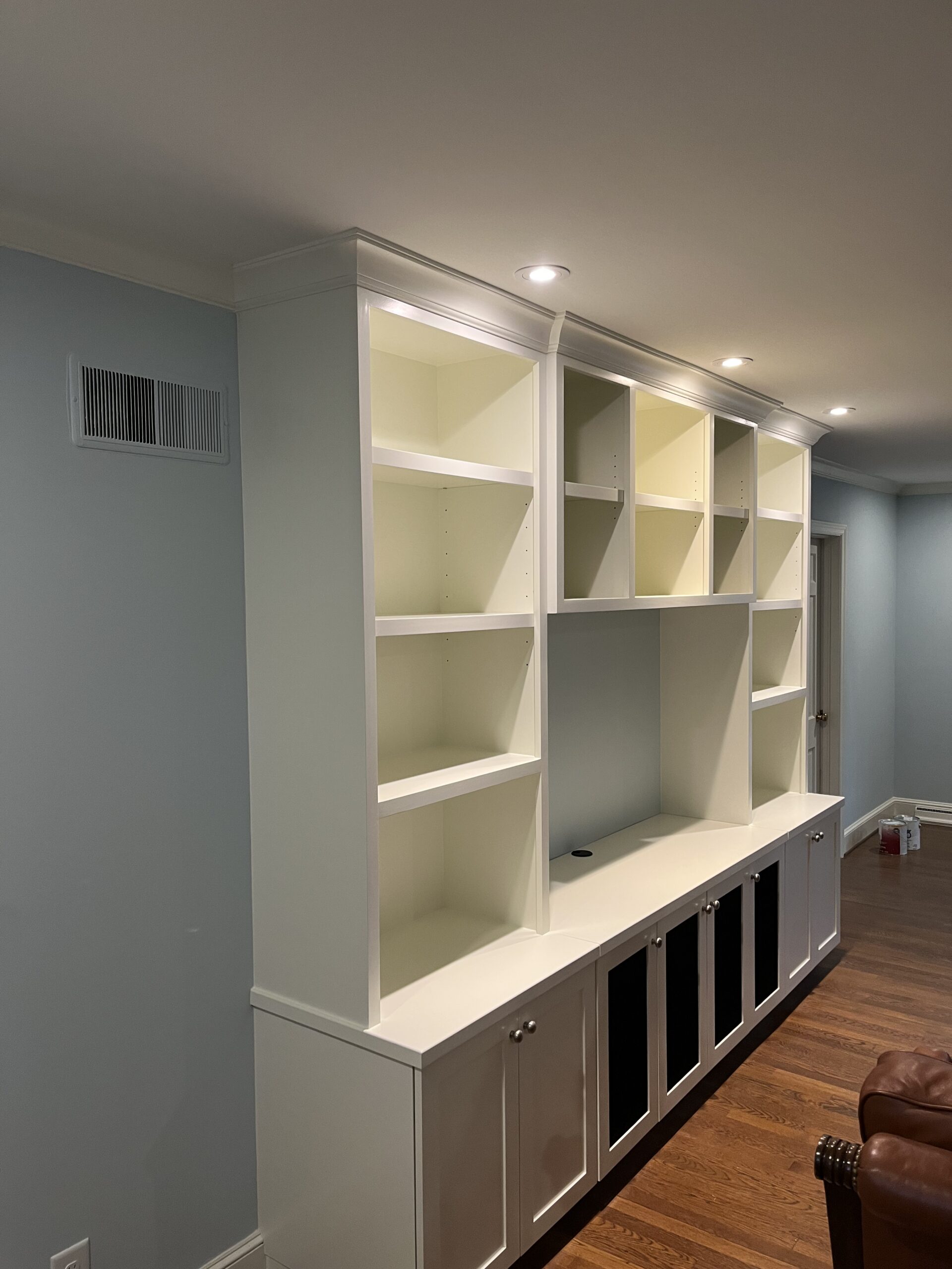 Wall of white built-in shelving and cabinets