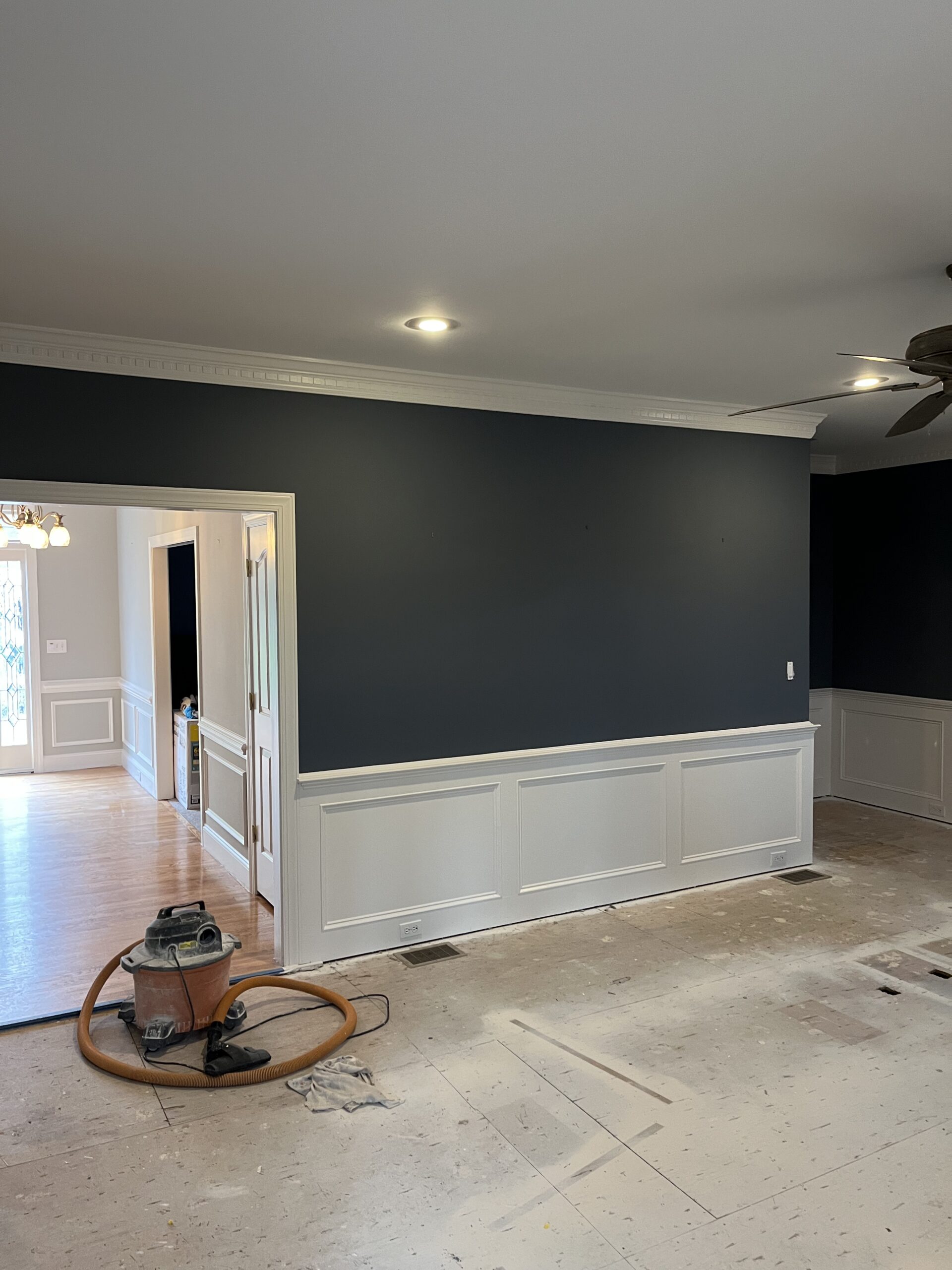 Interior wall painting in progress with navy accent wall