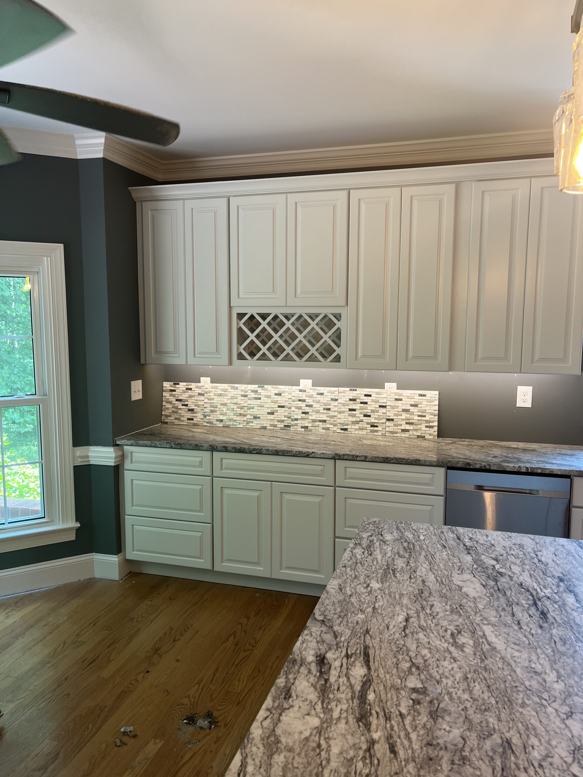 White kitchen cabinets with tile backsplash and granite island