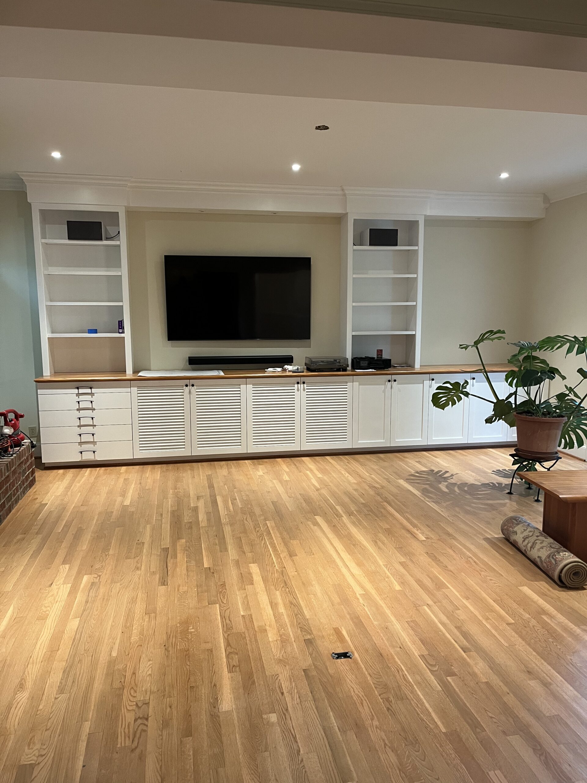 Living room with white built-in cabinets and hardwood floors