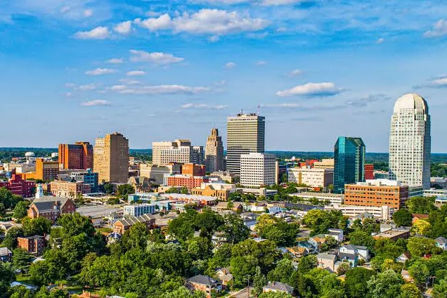 Downtown Winston-Salem skyline above tree-lined neighborhoods in Forsyth County, NC